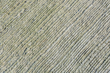An abstract image of the rough texture of an old weathered concrete pad. 