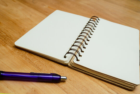notebook and pen over wooden background