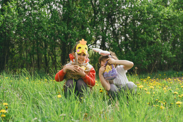 Easter egg hunt. Two children hunt for Easter eggs in a spring garden. Easter tradition. Laughing...