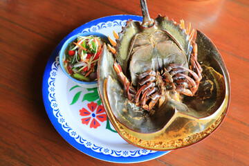 Steamed Horseshoe crab egg serve with spicy sauce in plate on wooden table. - 761953187
