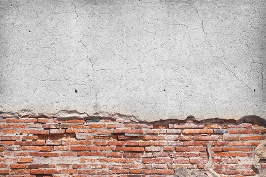 Grey concrete wall with old red brick decay on background