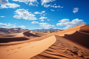Sand dunes rising against blue sky in desert landscape