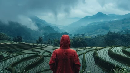 Fotobehang The back of a young man wearing a red hood Walking on terraced rice fields With a magnificent view of Sao Yokarn Mountain © 2D_Jungle