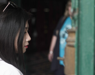 Woman wearing sunglasses while standing against trees,Young woman wearing sunglasses against wall,Thoughtful young woman against gray background,Rear view of woman standing against white wall