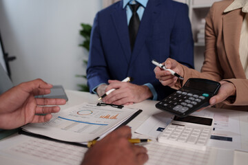 Business teamwork discussing brainstorming and calculating with a calculator on evaluation data in the conference room Focus on business growth and point out financial accounting charts.