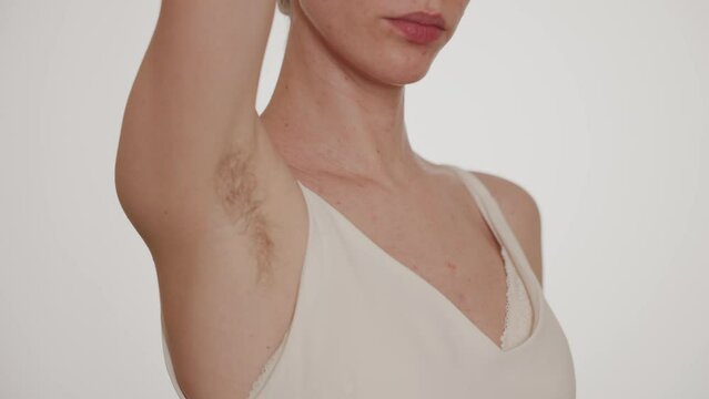 A young woman shows off her hairy armpits.