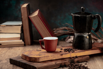 coffee cup and coffee beans on wood with old books in the background