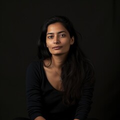 A woman with a dark complexion sits in a chair against a black background. Fictional character created by Generated AI. 