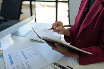 Call center, customer support worker, Asian businesswoman wearing headset working with PC computer, laptop talking to support customer. Record data. Check financial business information online.