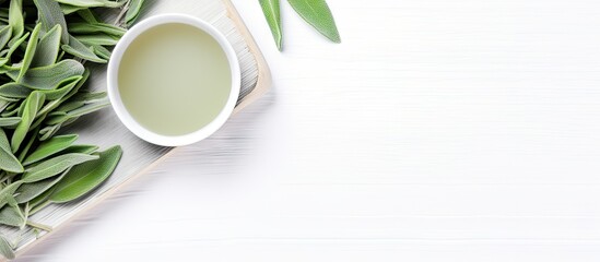 Green tea cup and leaves on white wooden table - obrazy, fototapety, plakaty