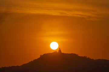 The sun circles in the red sky above Phuket  Big Buddha..Amazing Phuket big Buddha in circle of the...