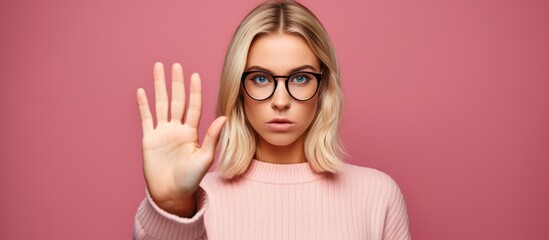 A woman wearing glasses stopping with hand signal