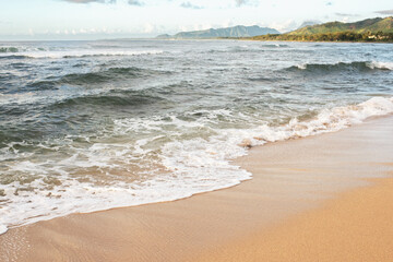 Waves crashing at a tropical island beach at sunrise