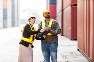 Caucasian woman supervisor and Indian man industrial worker work with tablet at a container yard. Shipping business management and international goods import-export. Concept of Logistic operation. - 762032520