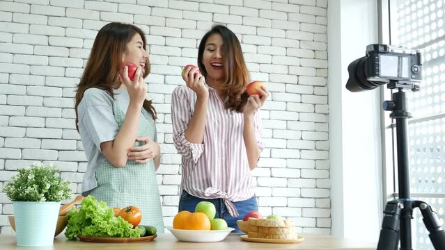 Asian influencer vlogger live review tomato skin care healthy eating lifestyle. Two Young Women Friends blogger vlog Happy Lifestyle vitamin C tomato vegetable fruit. Vlog Two women talk social media