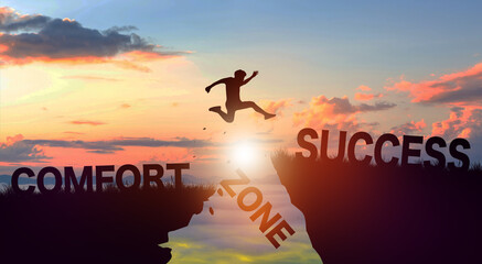 Silhouette man jumping form cliff to another mountain with Comfort zone to Success. Successful in business Concept. Copy space.