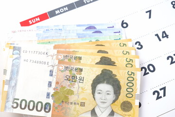 カレンダーと韓国の通貨、ウォンKRWの紙幣で、待ちに待った韓国旅行のイメージ
