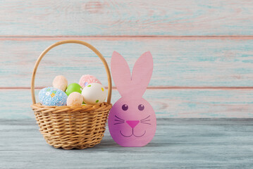 A basket full of Easter eggs and a rabbit figurine - 762054526