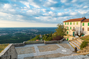 Sacro Monte of Varese (UNESCO site), Italy. Panoramic terrace overlooking the Po Valley with the 14th chapel of the sacred way, the city of Varese and Milan on the horizon