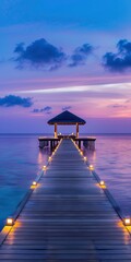 A long wooden pier with lights leads to an overwater gazebo at dusk.