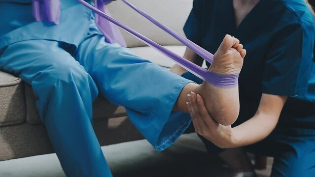 Asian female physiotherapist helping senior older woman stretching hamstring, Rehabilitation physiotherapy, elderly. Causes knee pain, swelling, redness, stiffness in knee, clunking noise in knee.