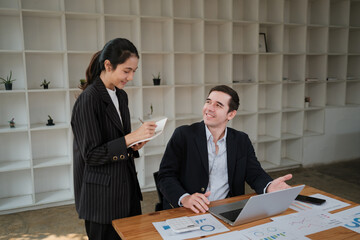 Company CEO and Top Manager Talking, Using Laptop Computer in office. Two Successful Professional People Brainstorm, Find Solution to Their e-Commerce Software Investment Strategy