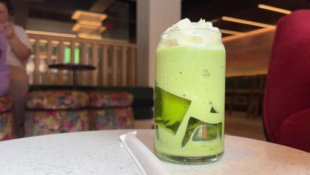 Green matcha tea and ice cubes on blue backgraound 