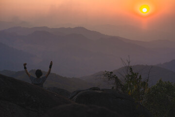 landscape and travel concept with solo freelancer man relax at top of mountain and sunset with...