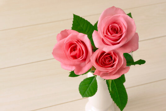 pink roses on a white table.  白いテーブルの上に置かれたピンク色のバラ