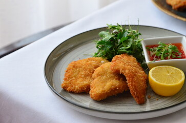 Schnitzel with potatoes and herbs on a plate in a restaurant