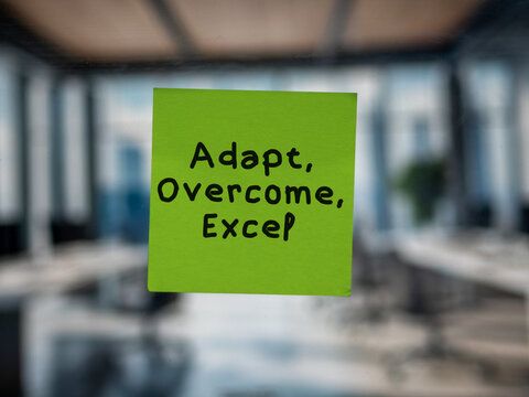 Post note on glass with 'Adapt, Overcome, Excel'.