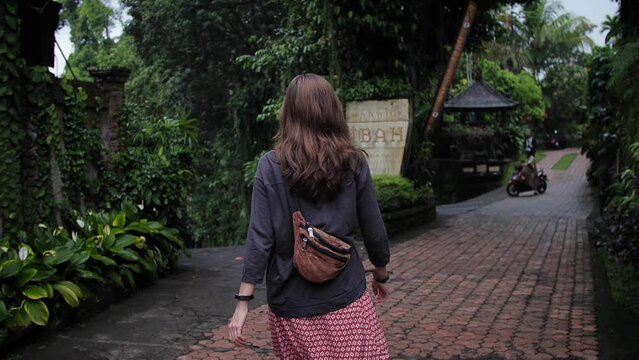 Woman walking from the back in the streets of Ubud. Bali, Indonesia. High quality FullHD slow motion footage.