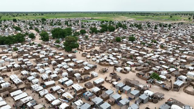Backward aerial view of displaced people in makeshift settlement in Sahel region