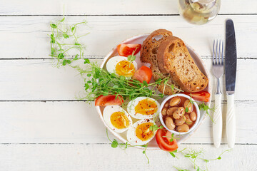 English breakfast. Boiled egg, beans, toast and green herbs. Top view, flat lay