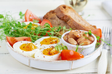 English breakfast. Boiled egg, beans, toast and green herbs.