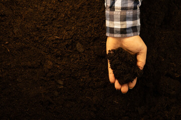 Handling the fertile soil above the ground in his hands the farmer studies the composition A farmer...