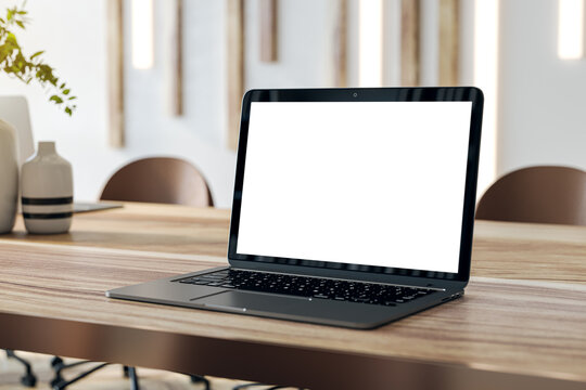 Laptop on a modern conference room table, isolated screen for creative mockups. 3D Rendering