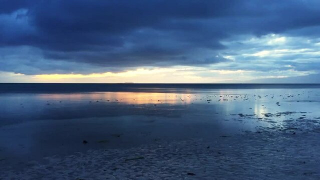The beautiful sunset in Siquijor Island. The dark clouds in the sky with colorful light from the sunset in the background. The dreamlike landscape in the Philippines.
