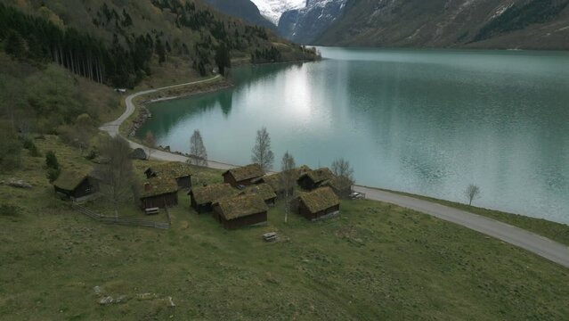 Traditional norwegian houses by the serene lovatnet lake, cloudy day, aerial view