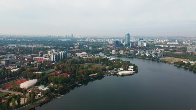 Floreasca lake with bucharest skyline, serene waters, urban landscape, cloudy day, cityscape backdrop, aerial view