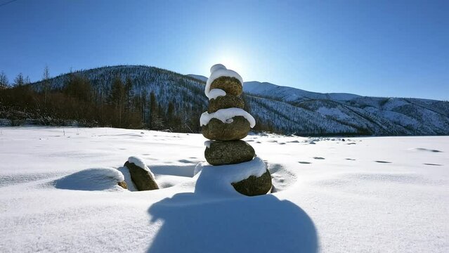 Sunrise, stone pyramid in snowy mountains: captivating image inspiring new discoveries.