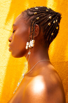 A young black woman with beaded cornrows 