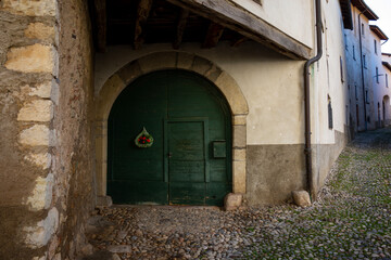 Fototapeta na wymiar Cobblestone Road to an Old Entrance House in a Sunny Day in Arzo, Ticino, Switzerland.