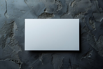 A blank white card rests against a black concrete background