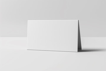 Naklejka premium A blank, folded white card rests on a table