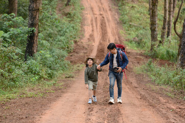 Happy traveler brother and girl are on the forest path and on the mountain edge.