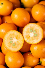 closeup of ripe cumquat or kumquat fruit with half background.