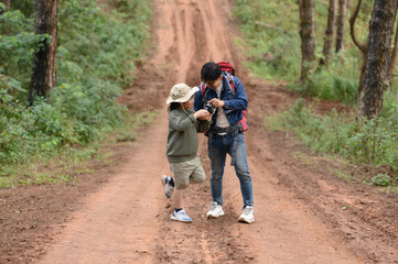 Happy traveler brother and girl are on the forest path and on the mountain edge.