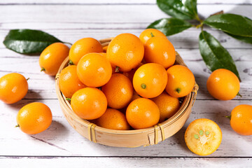 fresh ripe cumquat or kumquat fruit on wooden table.