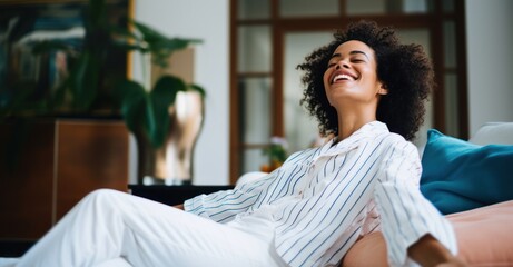 A cheerful woman finds relaxation on her home sofa, exuding happiness. Meanwhile, a smiling girl savors her day off, reclining on the couch - obrazy, fototapety, plakaty
